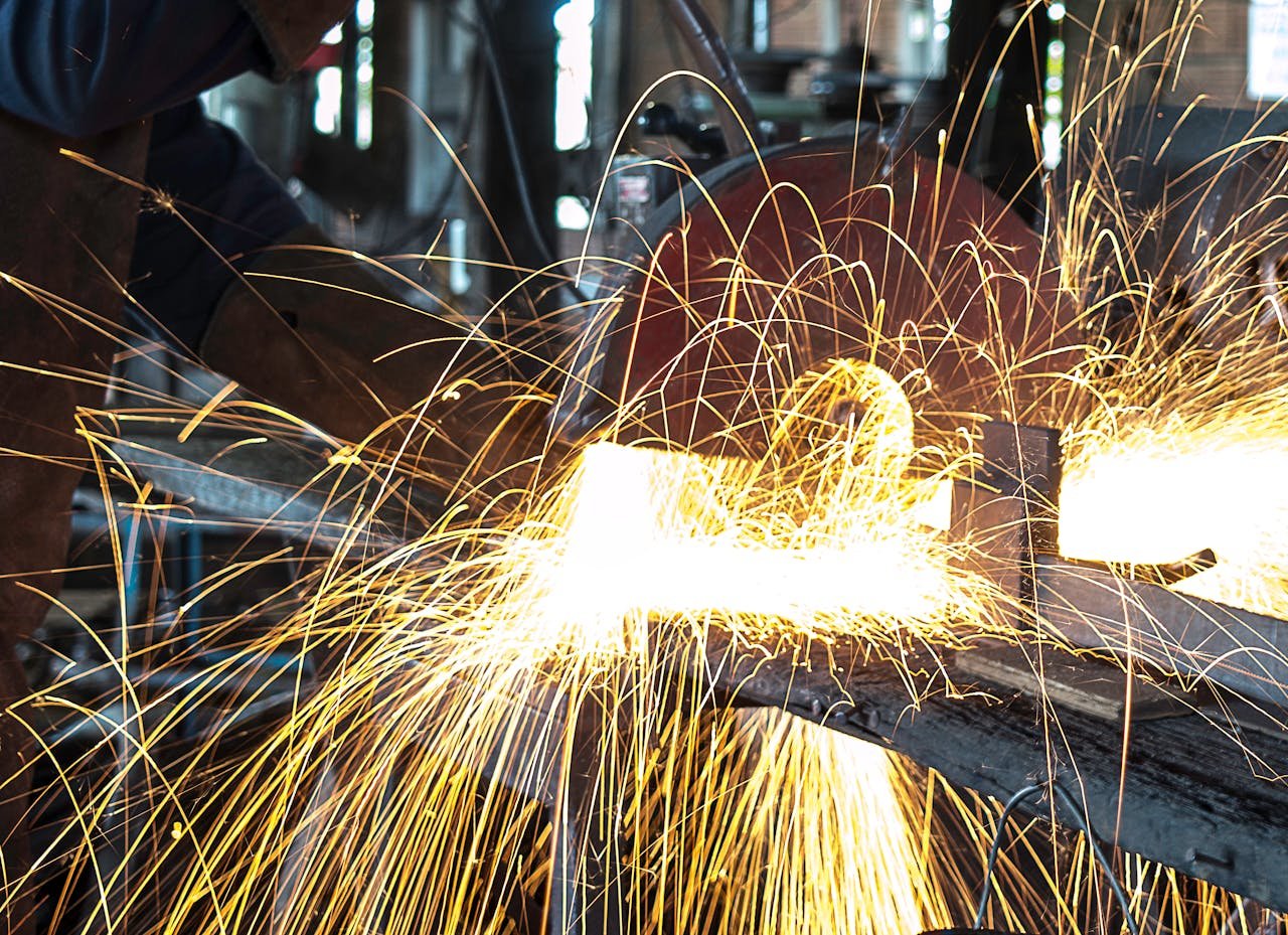 Contacto Soldadura en Creixell. Vibrant sparks fly during welding in a busy workshop, showcasing intense craftsmanship.