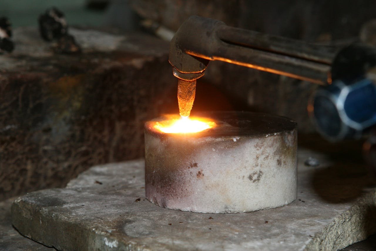 Servicios soldadura en Creixell. A close-up view of a metal smelting process using a torch, illustrating heat and sparks.
